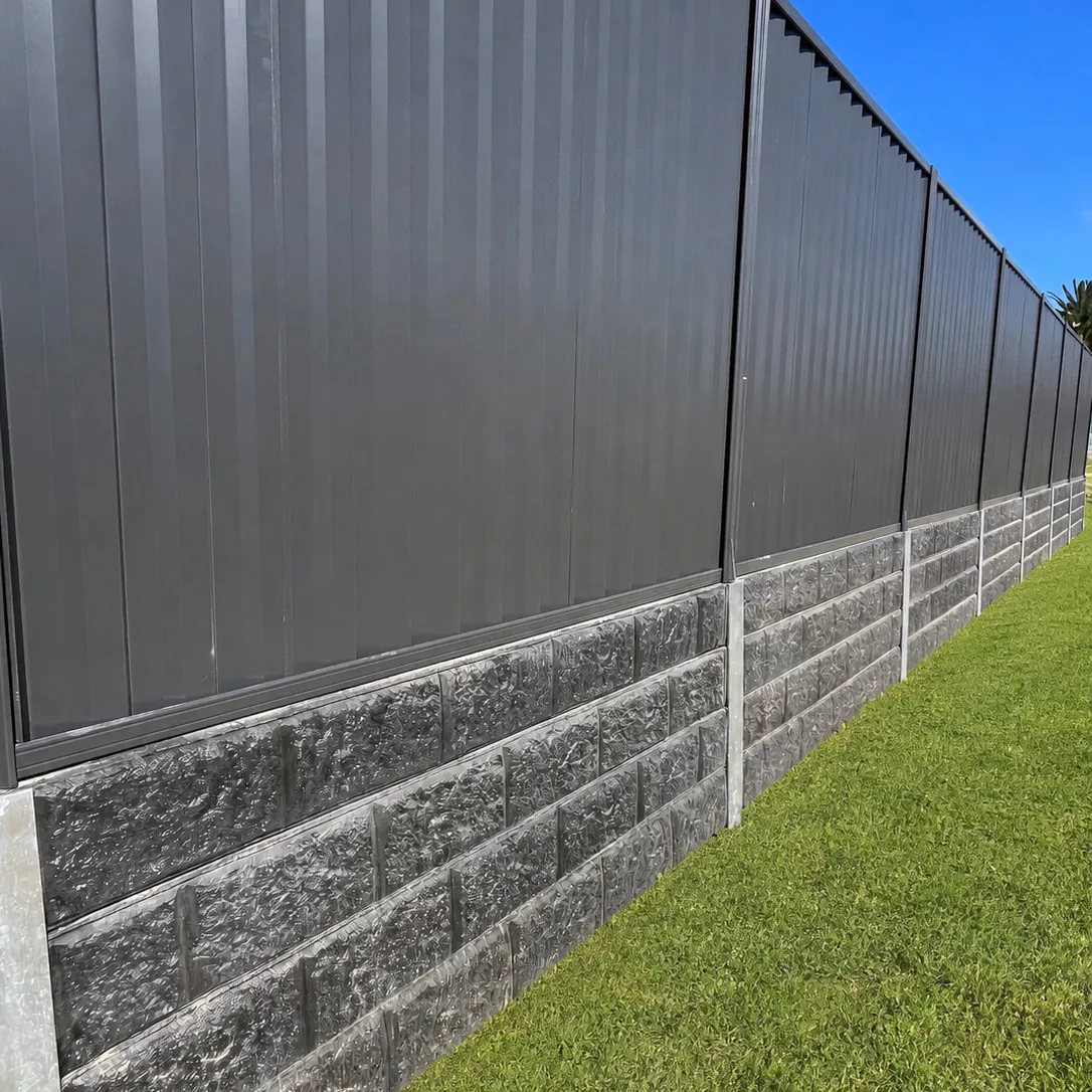 Close view of a charcoal metal fence above dark block-pattern concrete sleepers